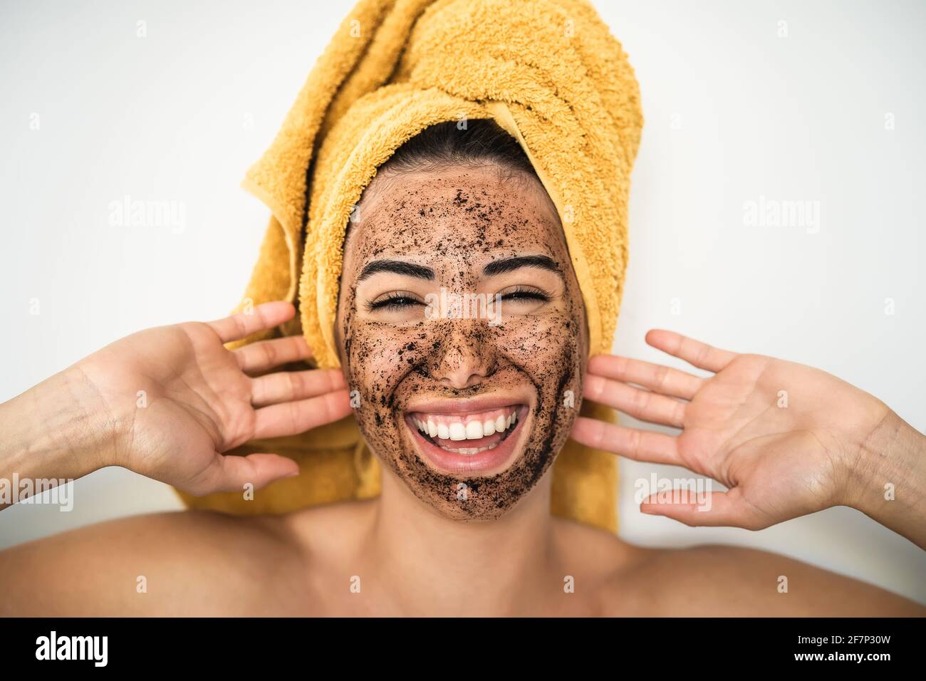 Jeune femme souriante appliquant un masque de gommage au café sur le visage  - heureuse fille ayant soin de la peau spa jour à la maison Photo Stock -  Alamy