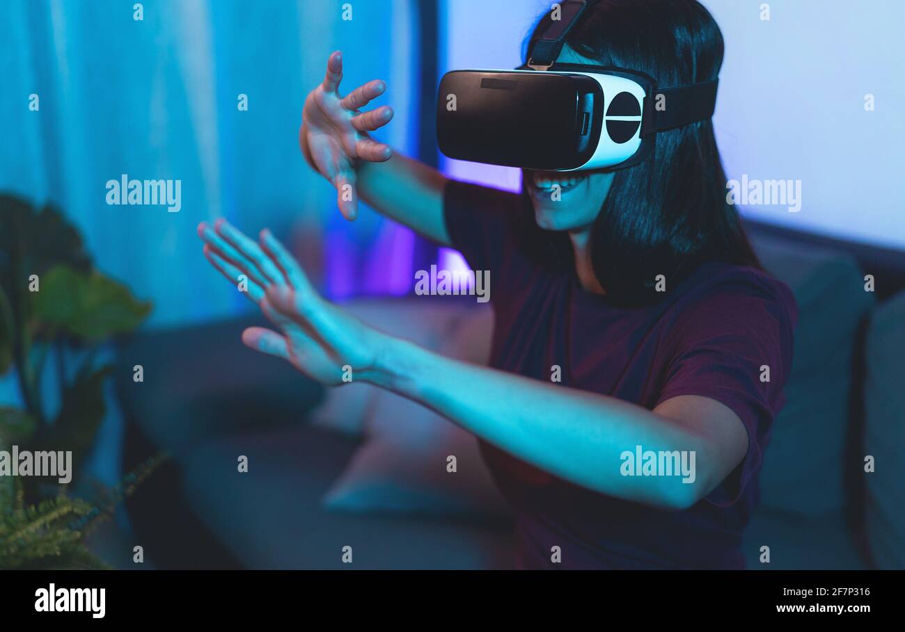 Jeune femme jouant avec des lunettes de réalité virtuelle à la maison - Joyeux adolescent s'amuser avec la technologie VR Googles innovante Banque D'Images