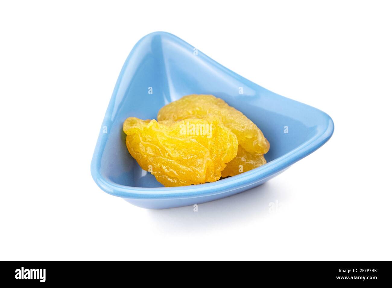 Fruits de poire séchés dans un bol bleu isolé sur fond blanc. Deux poires confites Banque D'Images