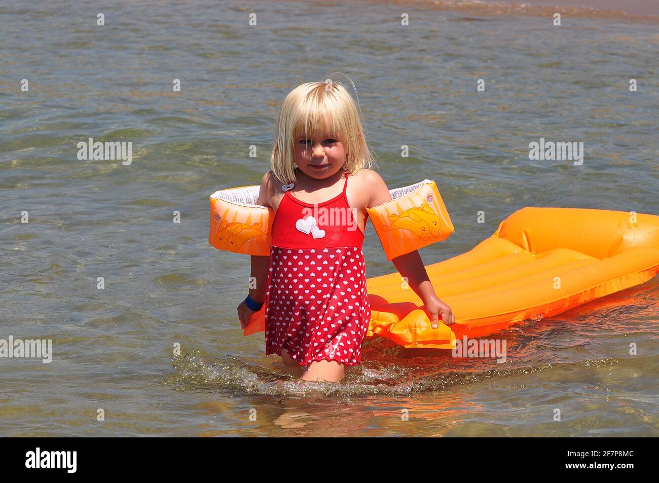 Petite fille avec des brassards et matelas d'air dans l'eau peu profonde, dinde Banque D'Images