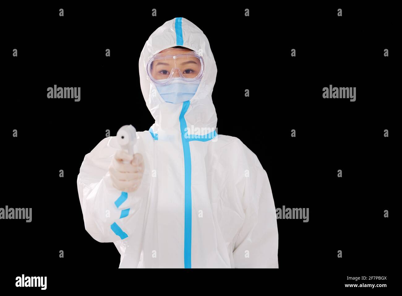 Une femme médecin en vêtements de protection médicale prend de la température Banque D'Images