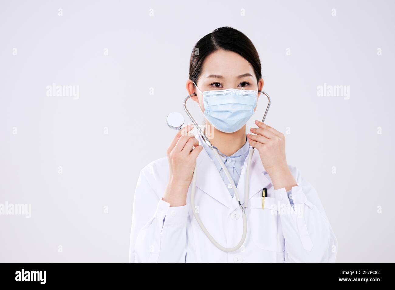 Une femme médecin a mis sur un stéthoscope regardant le appareil photo Banque D'Images