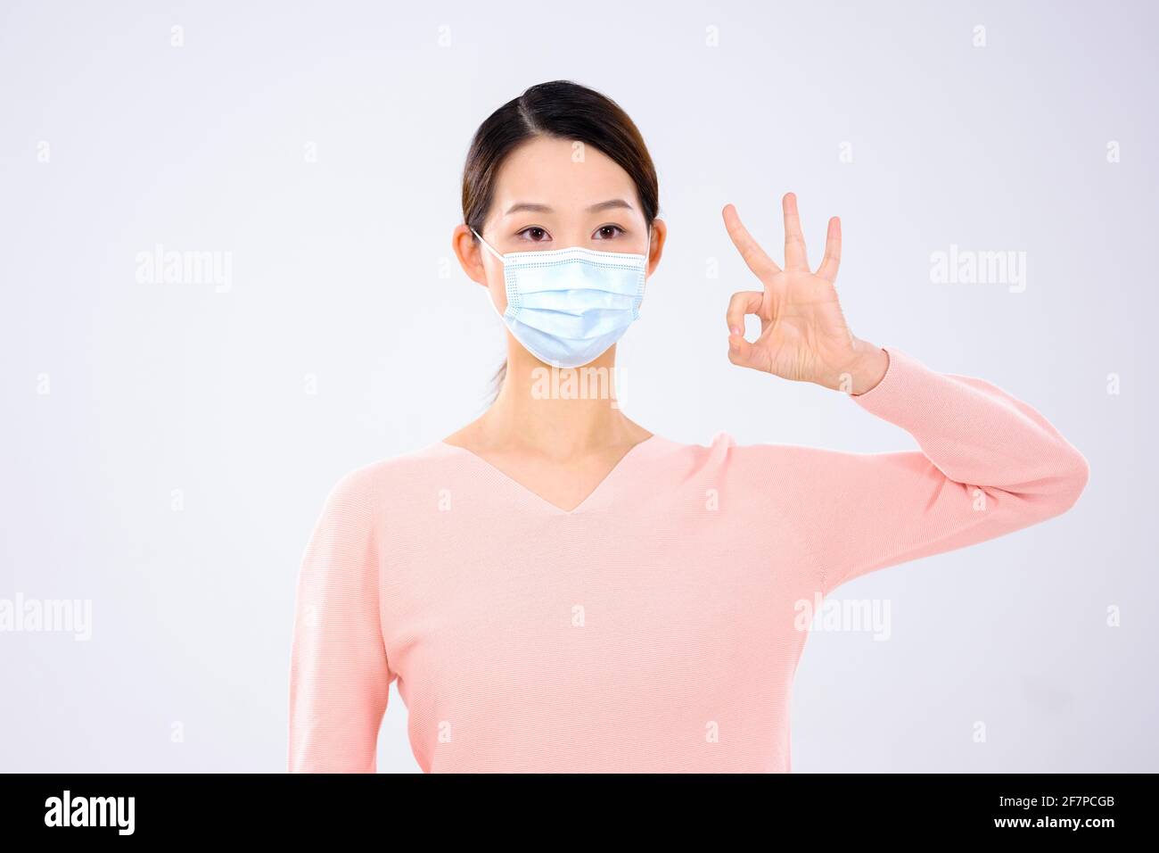 Une jeune femme portant un masque en a fait un signe vue avant du consentement Banque D'Images
