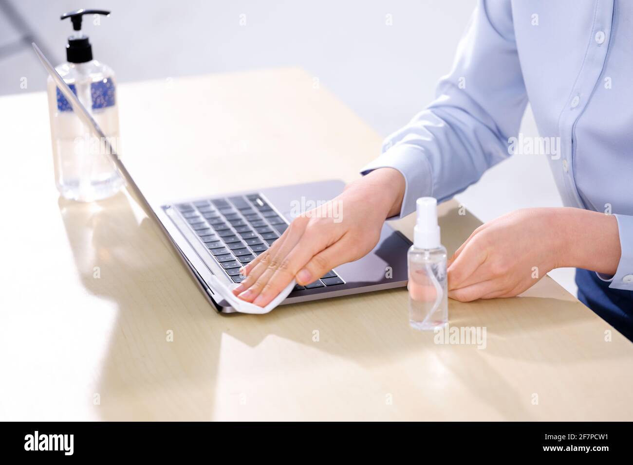 Une femme d'affaires essuie son ordinateur avec de l'alcool Banque D'Images
