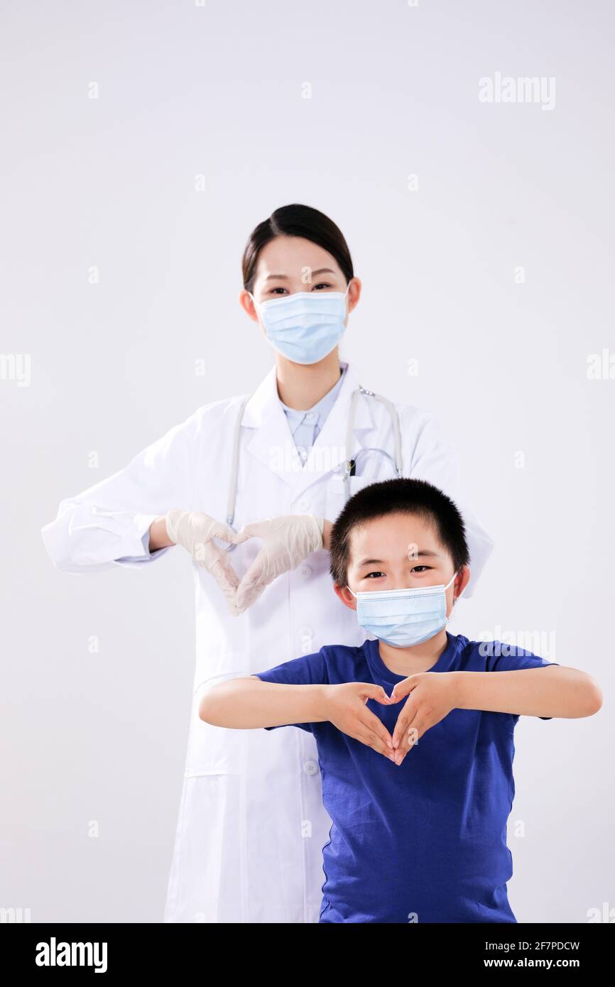 Une femme médecin et un petit garçon ont fait le coeur à mouvements du cœur en regardant la caméra Banque D'Images