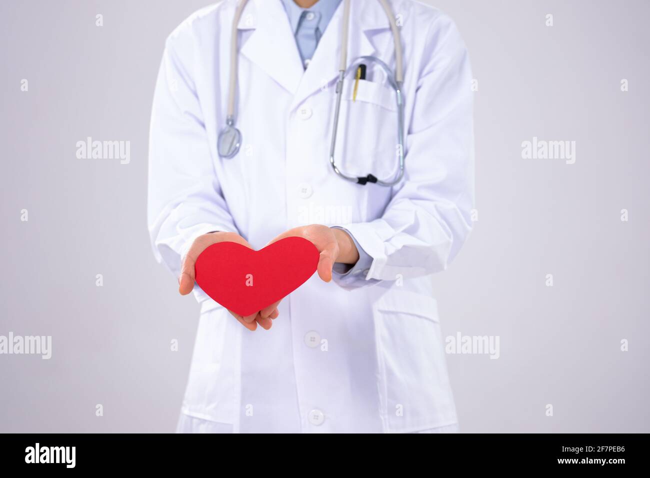 Une jeune femme médecin avec un masque a un rouge gros plan du cœur Banque D'Images