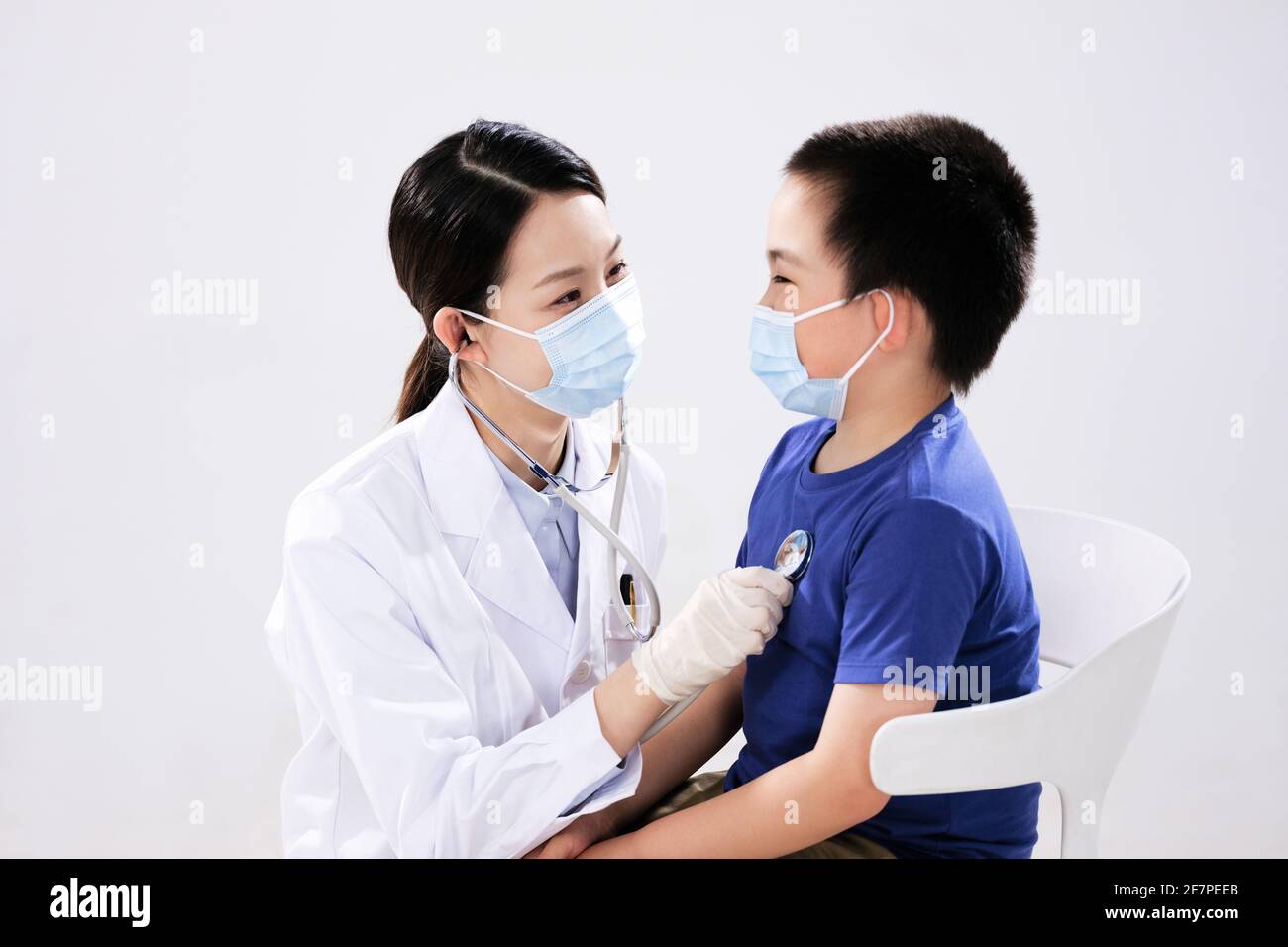 Une femme médecin a ausculté le petit garçon face à face Banque D'Images
