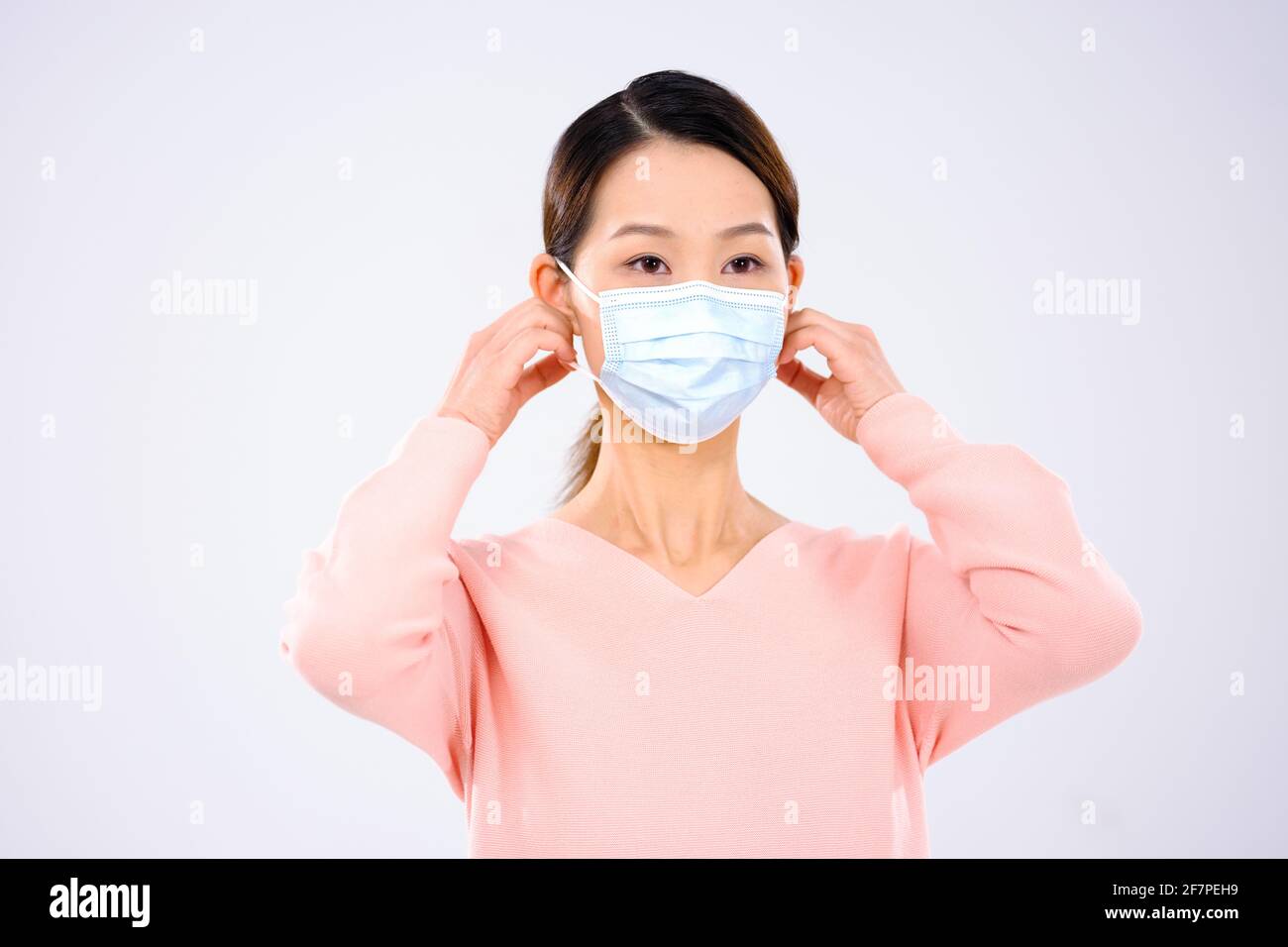 Une jeune femme portait un masque souriant Banque D'Images
