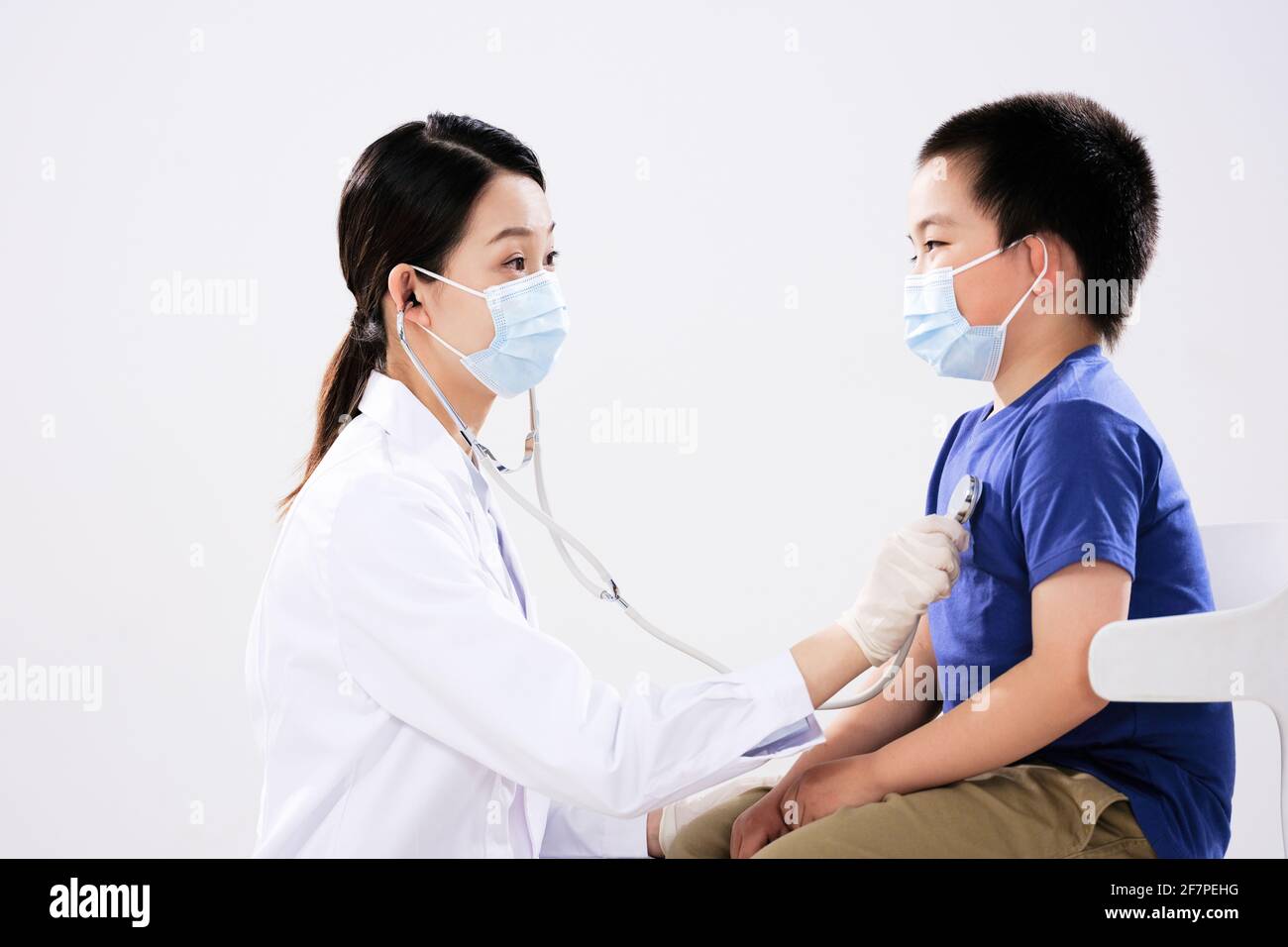 Une femme médecin a ausculté le petit garçon face à face Banque D'Images