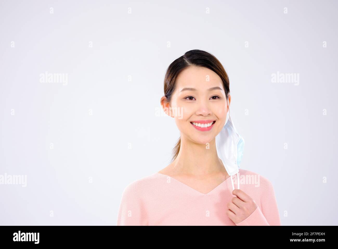 Une jeune femme a pris son masque en souriant Banque D'Images