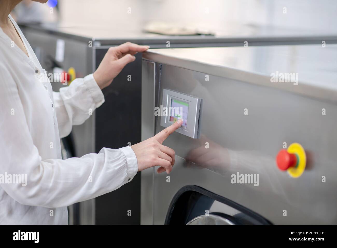 Les femmes touchent le panneau du lave-linge Banque D'Images