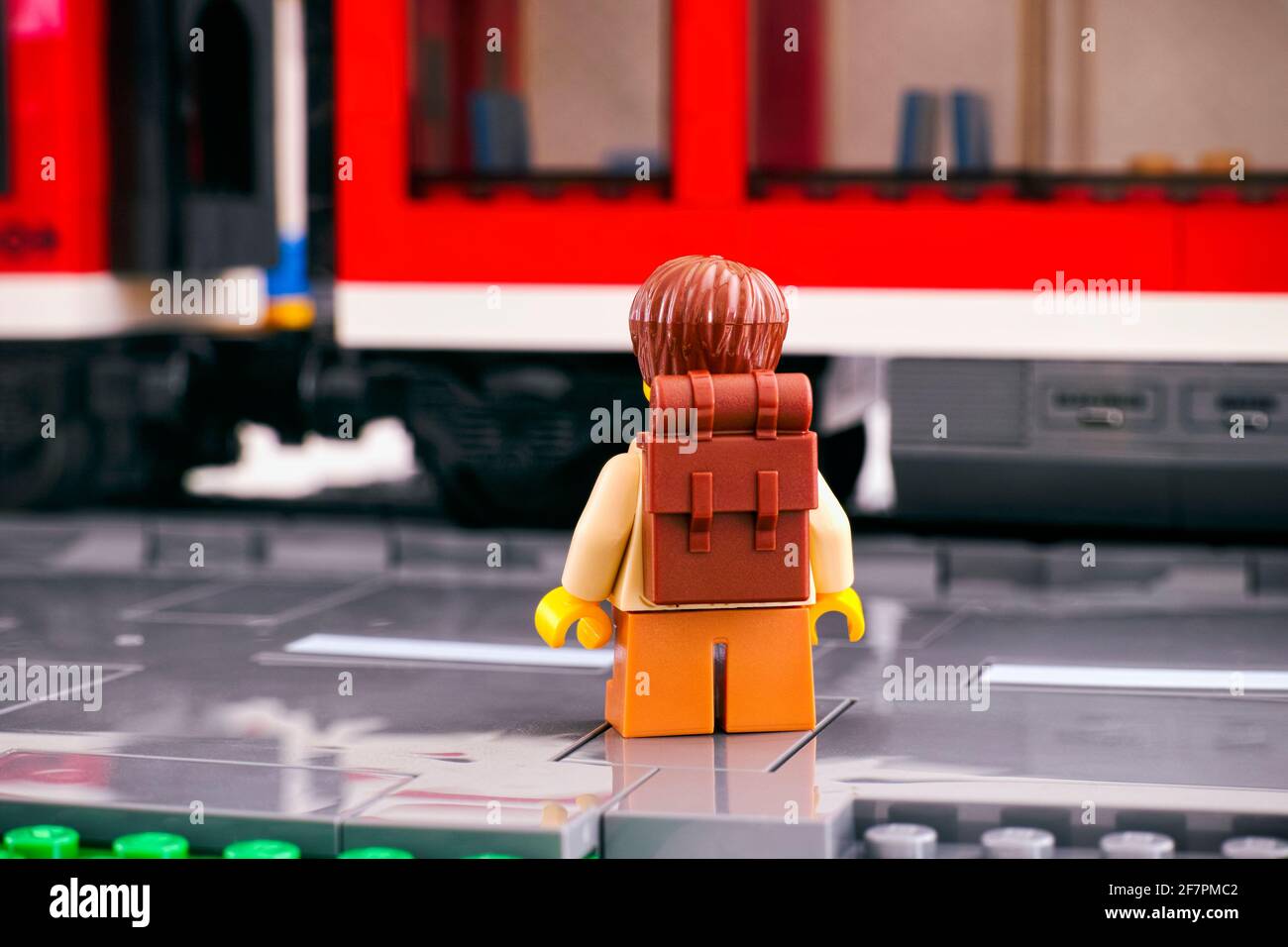Tambov, Fédération de Russie - 03 mars 2021 Lego touriste avec un sac à dos debout avec son dos vers la caméra sur la plate-forme devant un t rouge Banque D'Images
