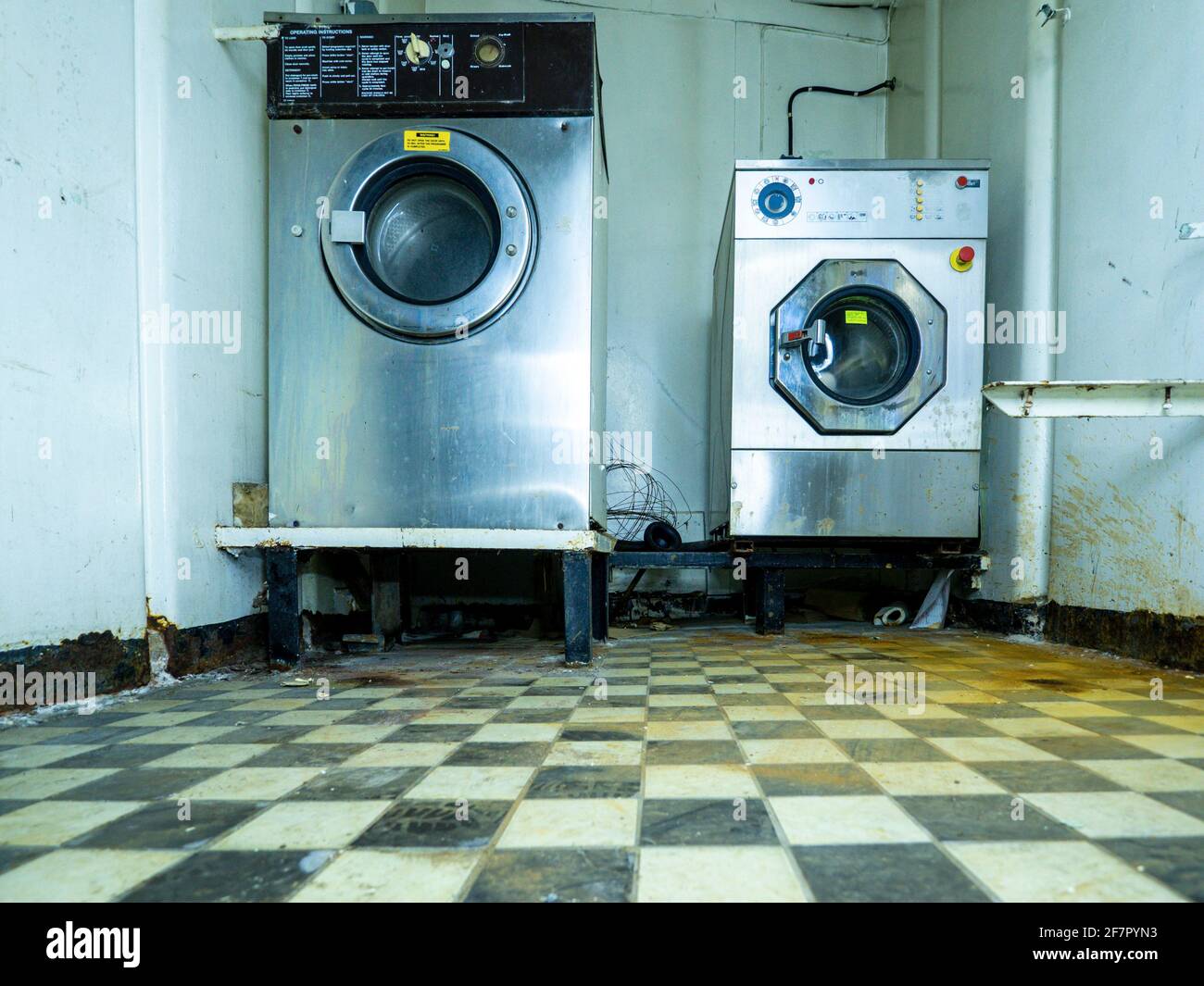 lave-linge et sèche-linge industriels dans un bâtiment abandonné Banque D'Images