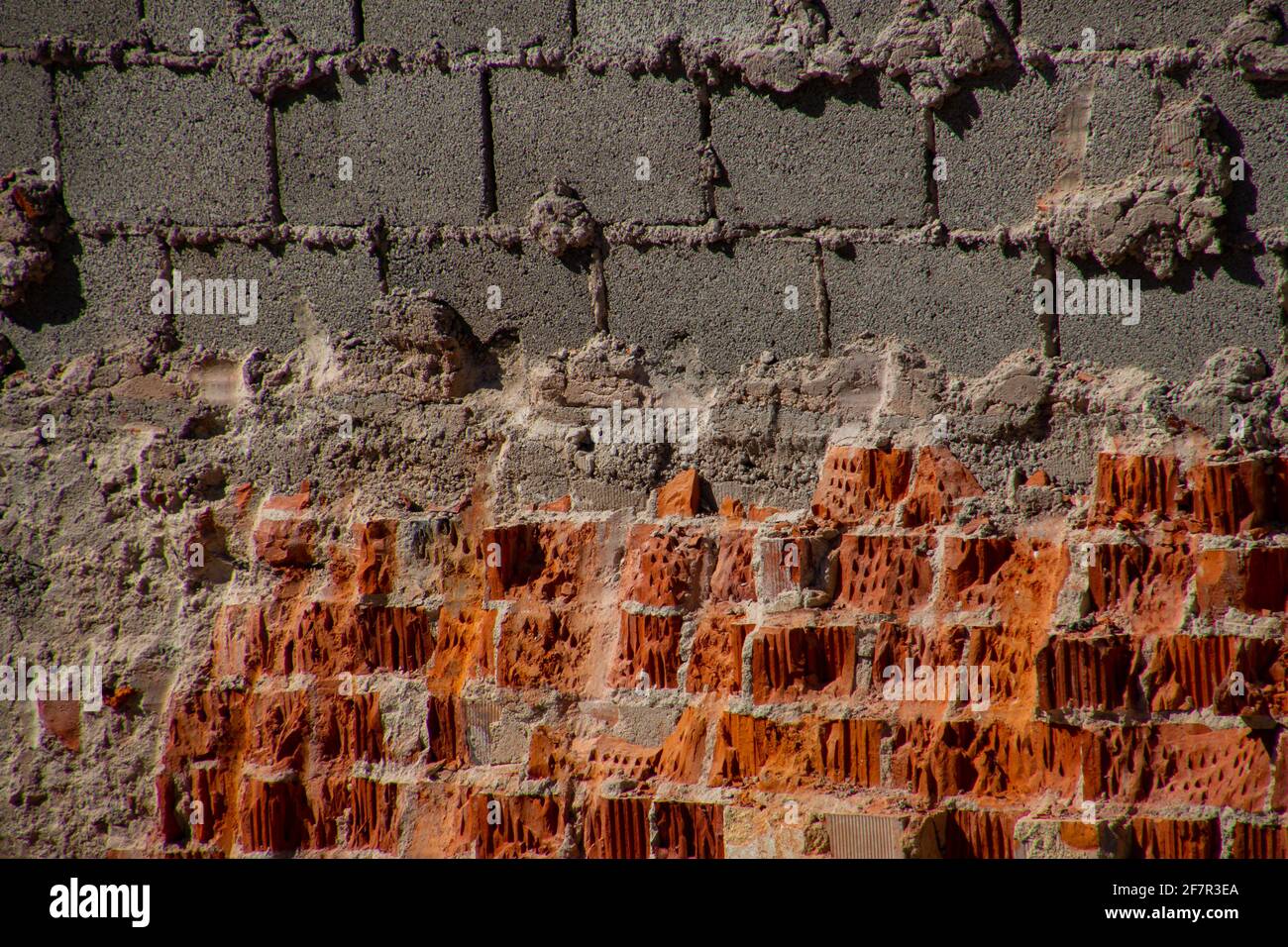 Mur de briques rouges brisées et bloc creux en béton gris briques Banque D'Images