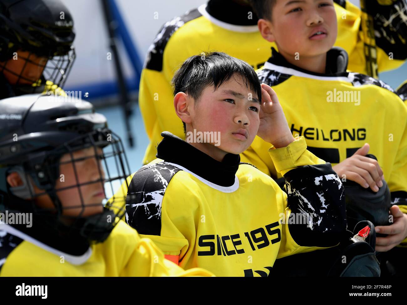 (210409) -- DENGFENG, le 9 avril 2021 (Xinhua) -- Fang Yuhao (C) de l'équipe de hockey sur glace Shaolin Tagou écoute les instructions de l'entraîneur pendant l'entraînement à l'école d'arts martiaux Shaolin Tagou, Dengfeng City, province de Henan, au centre de la Chine, le 30 mars 2021. Shaolin Tagou Martial Arts School, à quelques kilomètres du temple de Shaolin, lieu de naissance de Shaolin Kung Fu, construit son équipe de hockey sur glace. Les élèves apprennent le sport sur des patins à roulettes dans une patinoire de taille standard recouverte de plancher, au lieu de glace. La pratique des arts martiaux renforce leur physique et leur fournit des qualités athlétiques t Banque D'Images