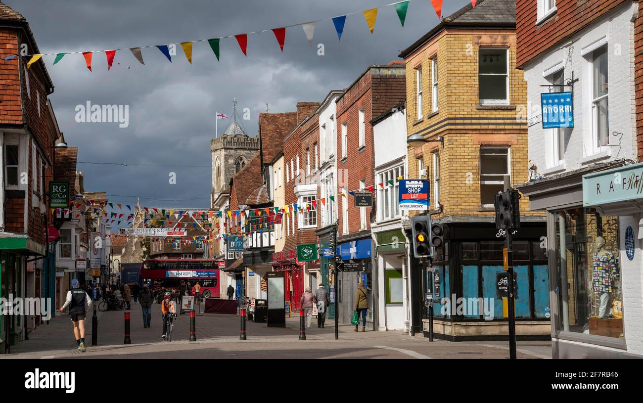 Salisbury, Wiltshire, Angleterre, Royaume-Uni. 2021. Zone commerçante du centre-ville de Salisbury pendant Civid verrouillage dans la lumière du soleil avec un ciel sombre de tempête. Banque D'Images