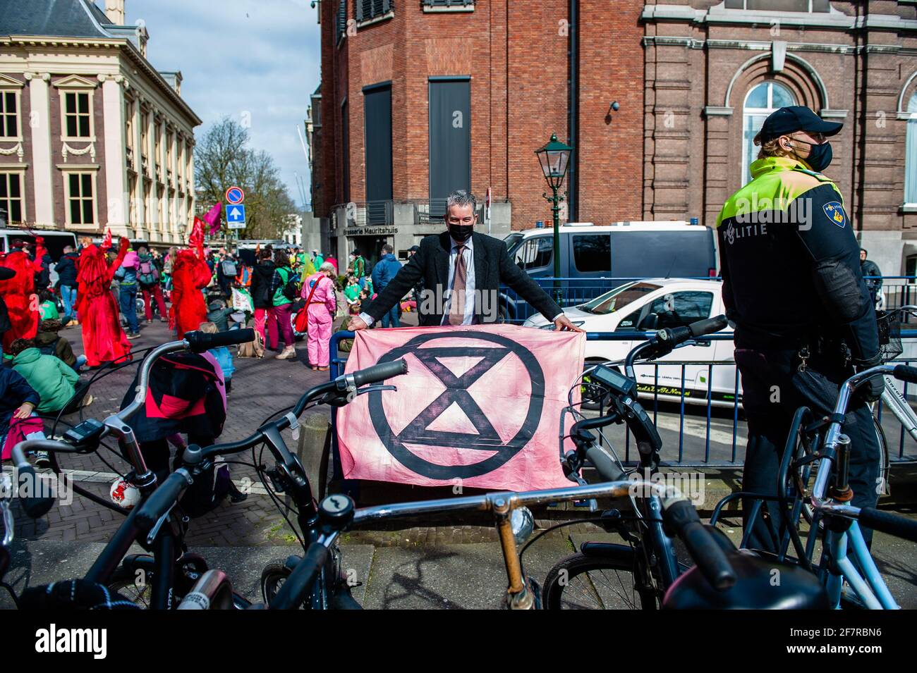 Un activiste portant un costume porte un drapeau XR devant un policier pendant la manifestation.pour mettre fin à sa campagne de rébellion de printemps, le groupe de lutte contre l'extinction rébellion a organisé une action de désobéissance civile pour faire savoir au gouvernement qu'il ne peut plus ignorer la crise climatique et écologique. Les premiers militants ont tenté d'entrer dans le Binnenhof, où la Chambre des représentants se réunit et où le Premier ministre travaille, mais la police a pu l'empêcher. Après cela, ils ont bloqué la Korte Vijverberg, une route qui mène à Binnenhof. La porte du Binnenhof était par-suite Banque D'Images