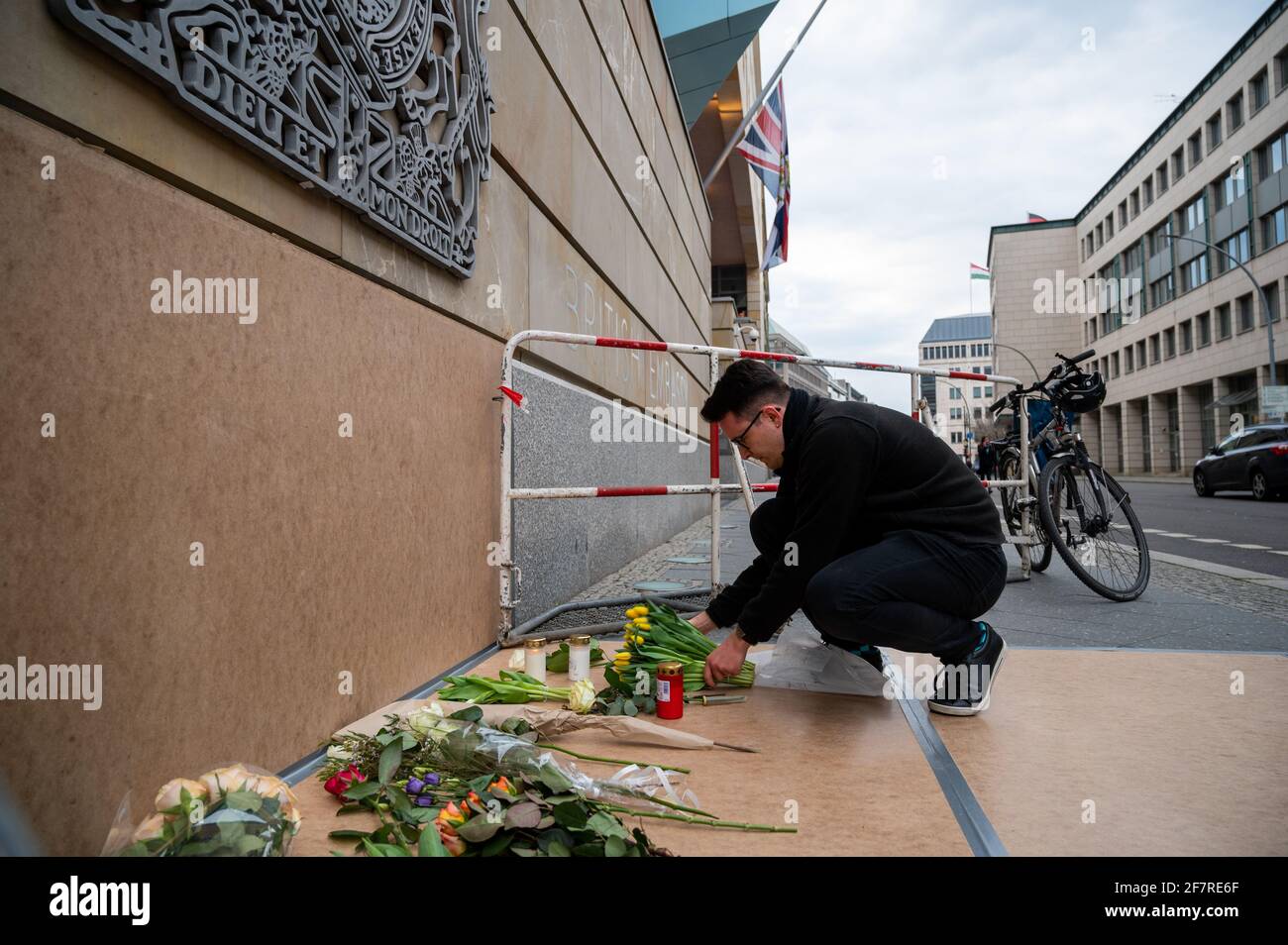 Berlin, Allemagne. 09e avril 2021. Un homme dépose des fleurs à l'extérieur de l'ambassade britannique tandis que le drapeau vole en Berne en arrière-plan. Le prince Philip, mari de la reine Elizabeth II de Grande-Bretagne, est décédé à l'âge de 99 ans. Cela a été annoncé par Buckingham Palace le 09.04.2021 à Londres. Credit: Christophe bateau/dpa/Alay Live News Banque D'Images