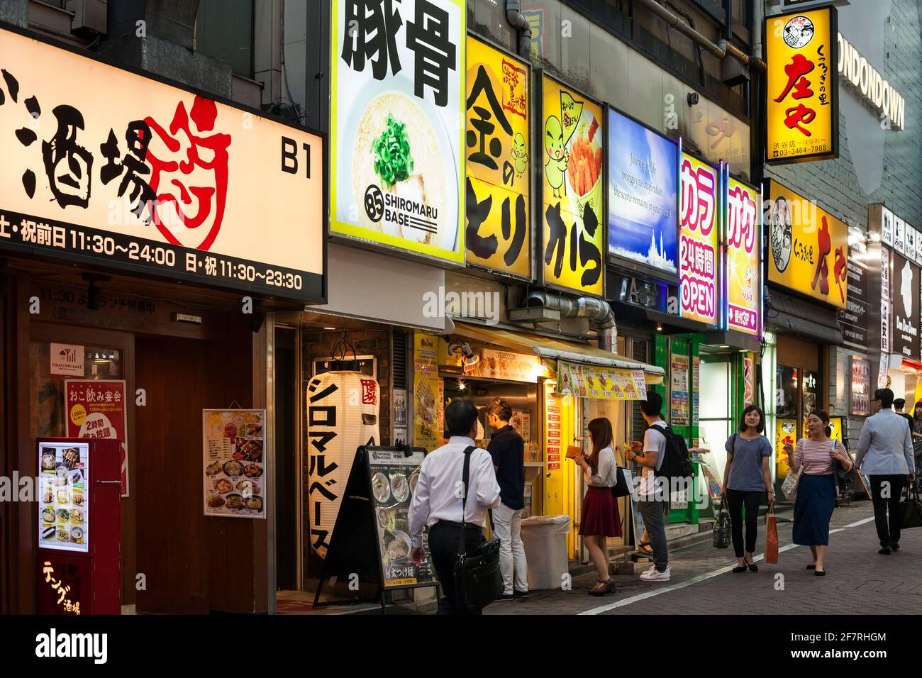 Vue horizontale d'une rangée de fast-foods et de restaurants plein de panneaux colorés au néon sur Shibuya Centre-gai, Shibuya, Tokyo, Japon Banque D'Images