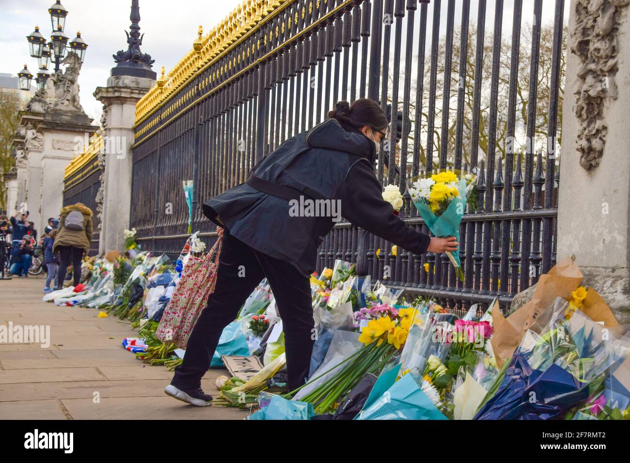 Londres, Royaume-Uni. 9 avril 2021. Une femme dépose des fleurs en hommage au prince Philip à l'extérieur de Buckingham Palace. Le duc d'Édimbourg est mort aujourd'hui, âgé de 99 ans. Credit: Vuk Valcic/Alamy Live News Banque D'Images