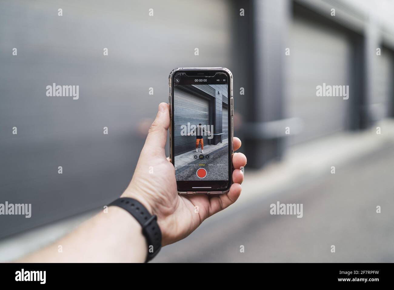 Main mâle tenant un téléphone et faisant la vidéo d'un ami Banque D'Images