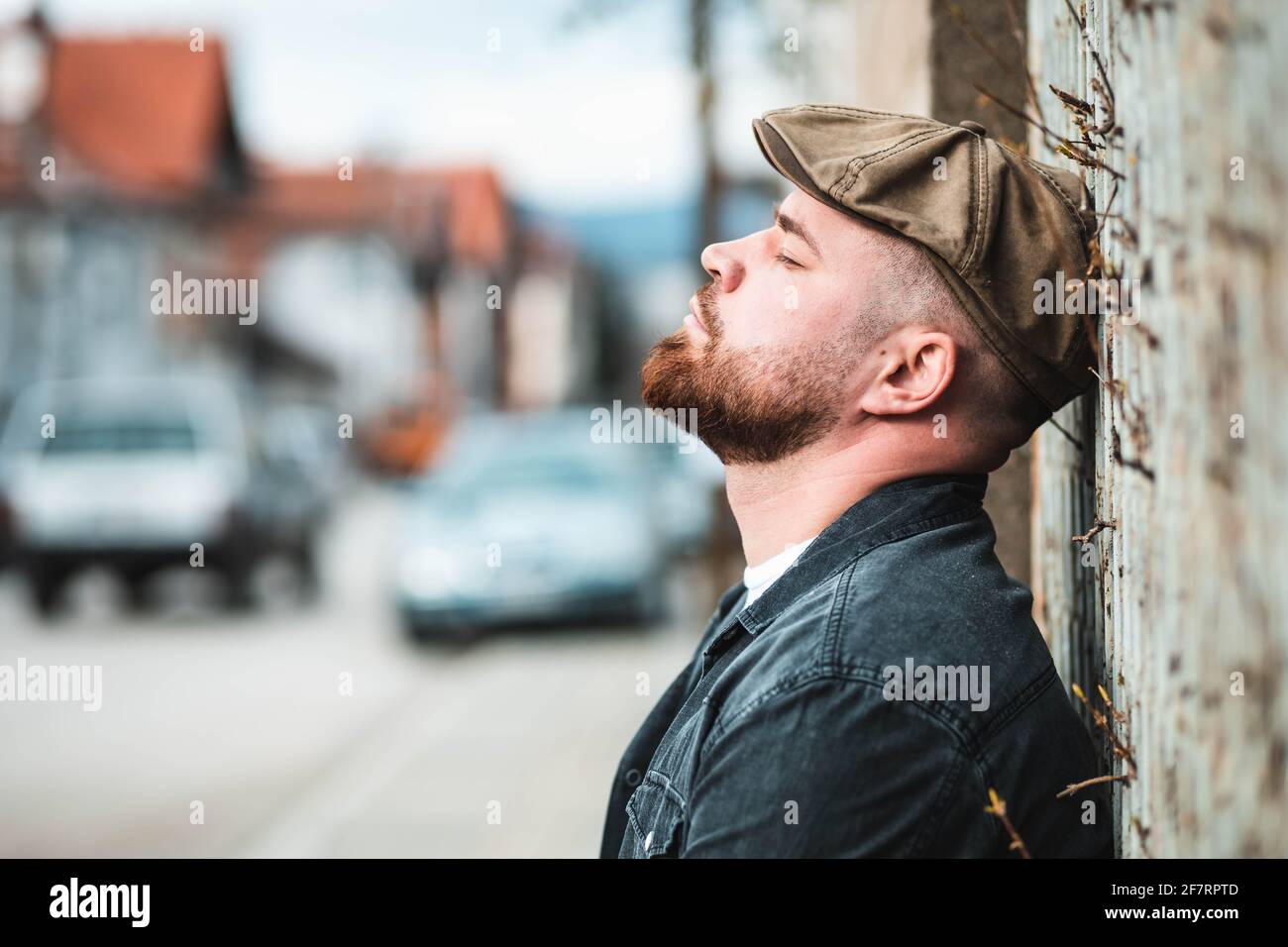 Portrait d'un beau gars avec un chapeau de lierre appuyé sur le mur Banque D'Images