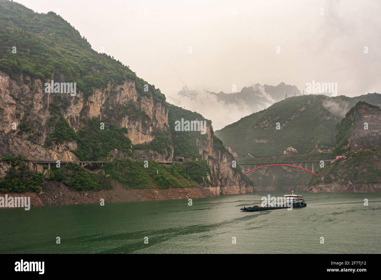 Rivière Yangtze, trois Gorges, Chine - 6 mai 2010 : région de Zigui. La barge de charbon navigue sur l'eau verte devant les collines boisées vertes et les montagnes avec l'être Banque D'Images