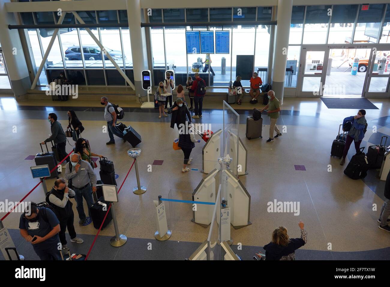 Passagers avec masque facial au guichet American Airlines du terminal 4 de l'aéroport international de Los Angeles, le vendredi 9 avril 2021, in Banque D'Images