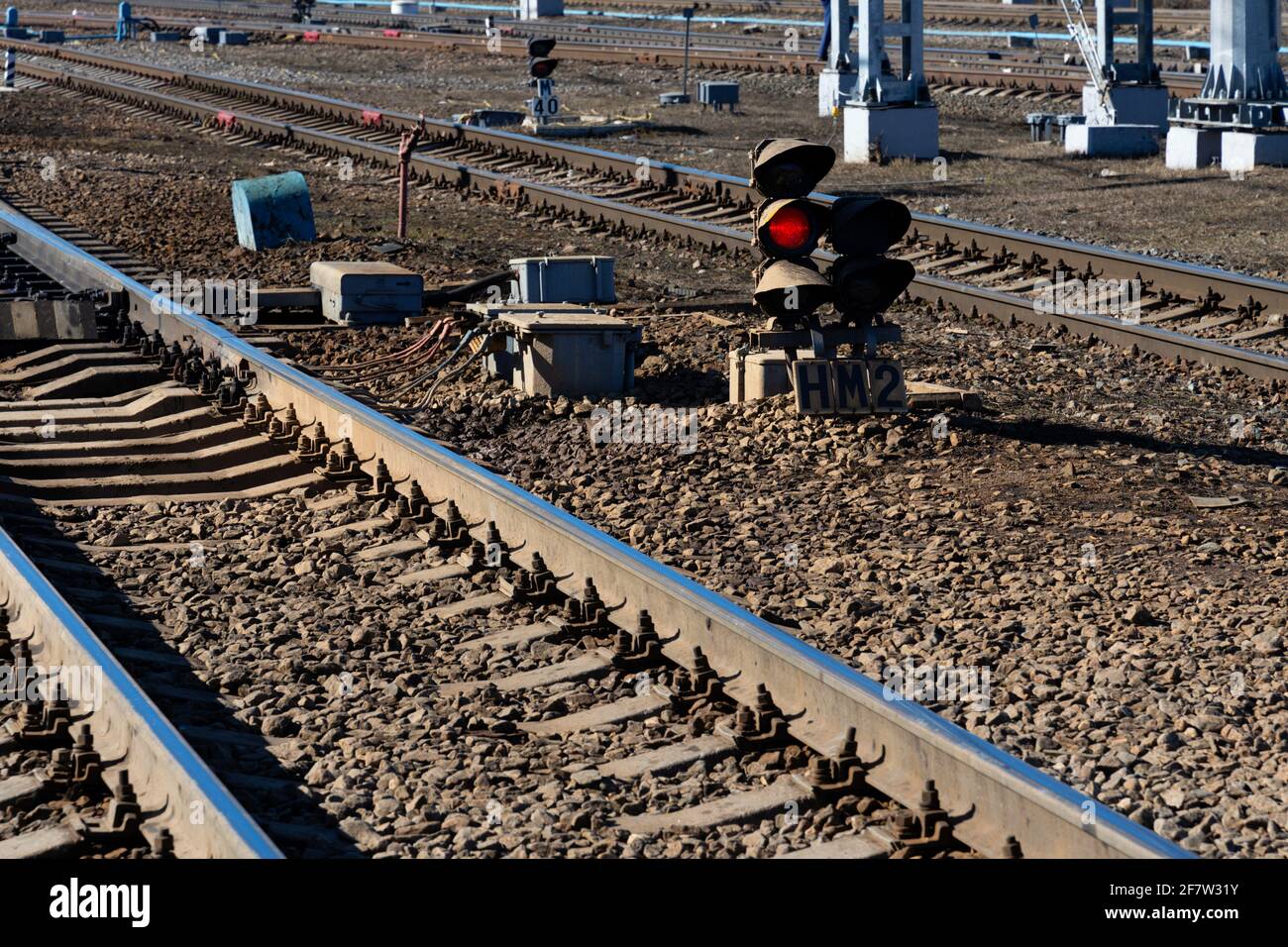 Remblai de chemin de fer avec rails et sémaphore rouge brillant de près sans marques commerciales Banque D'Images