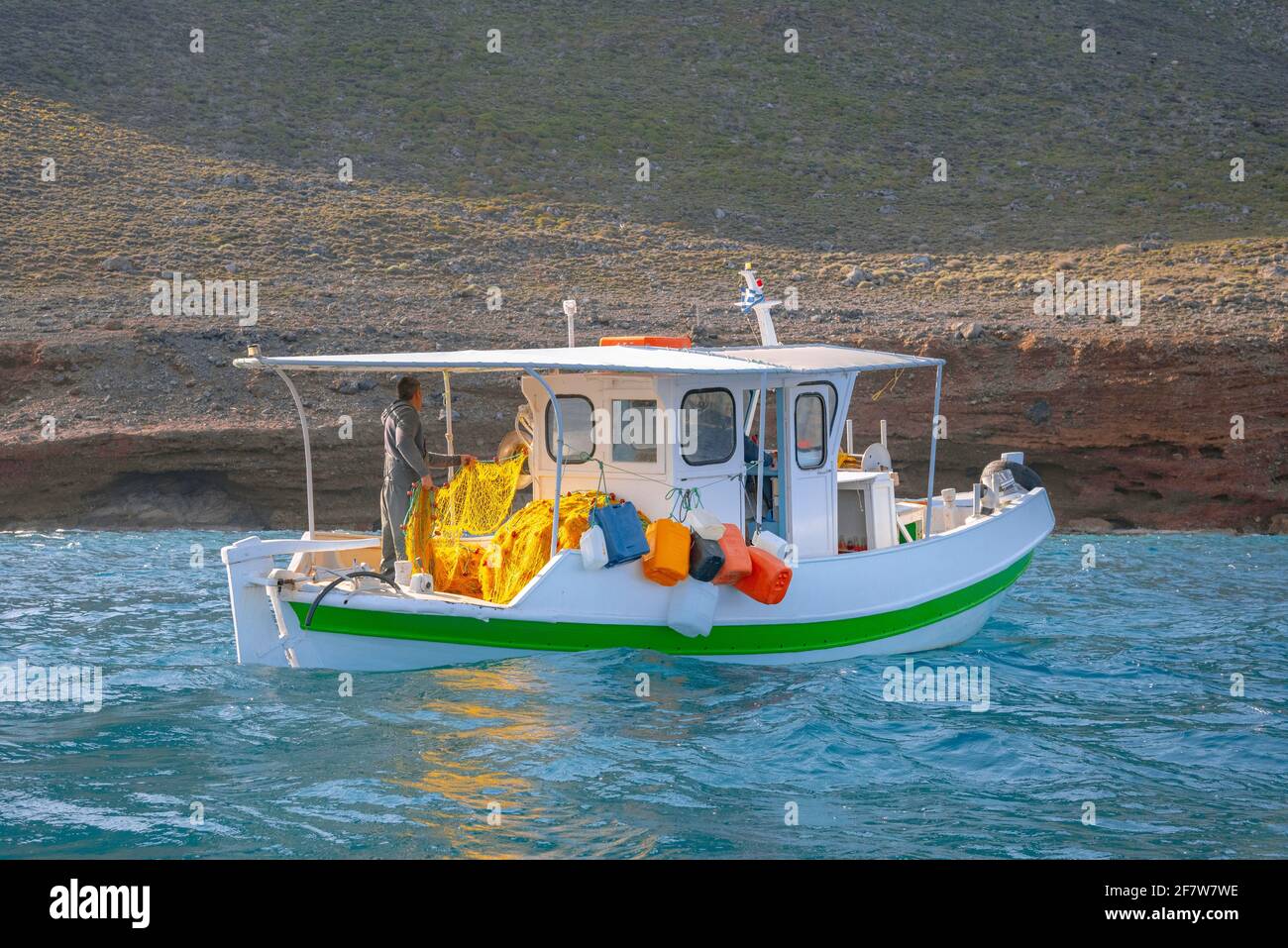 Les pêcheurs pêchent des poissons frais à l'aide de filets de pêche jaunes, sur un bateau de pêche, en Crète, en Grèce Banque D'Images