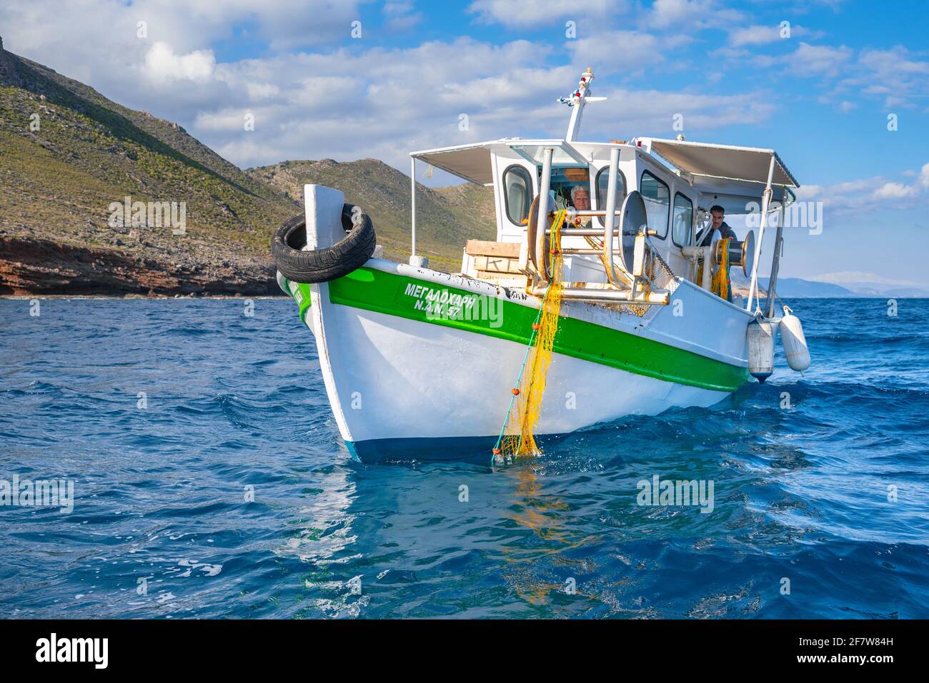 Les pêcheurs pêchent des poissons frais à l'aide de filets de pêche jaunes, sur un bateau de pêche, en Crète, en Grèce Banque D'Images