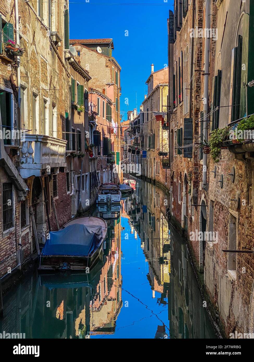 Bateaux, balcon avec plante dans une petite vieille rue colorée à Venise, Italie Banque D'Images