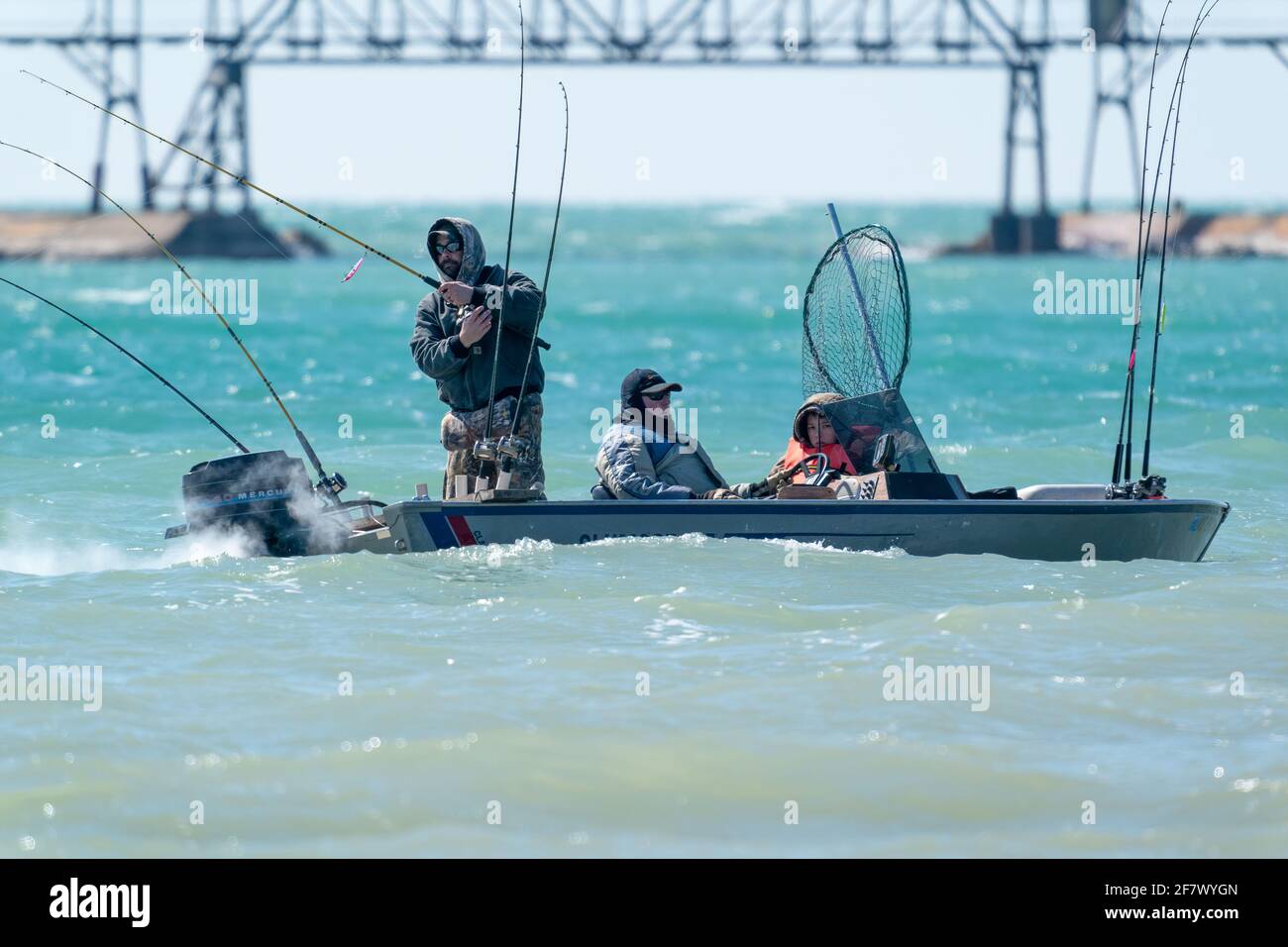 Les pêcheurs intrépides bravent le vent et le temps froid pour pêcher en début de saison près du brise-lames du canal de navigation de Sturgeon Bay, Wisconsin. Banque D'Images