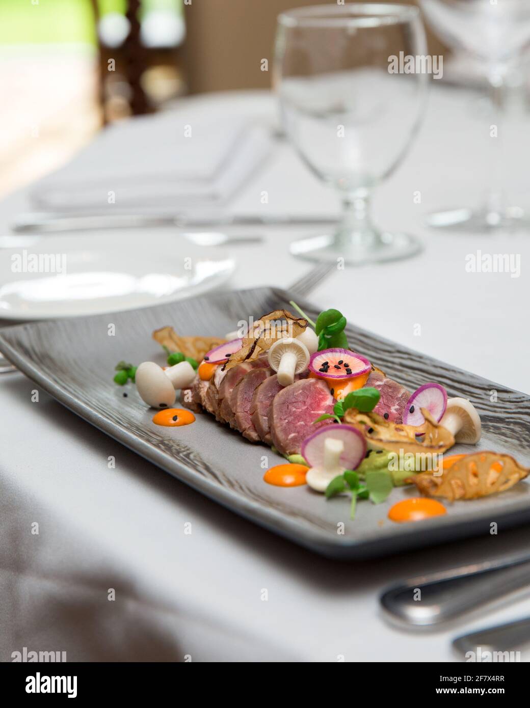 Tranché de bœuf avec décoration servi sur une longue assiette. Style de la  cuisine et repas au restaurant Photo Stock - Alamy