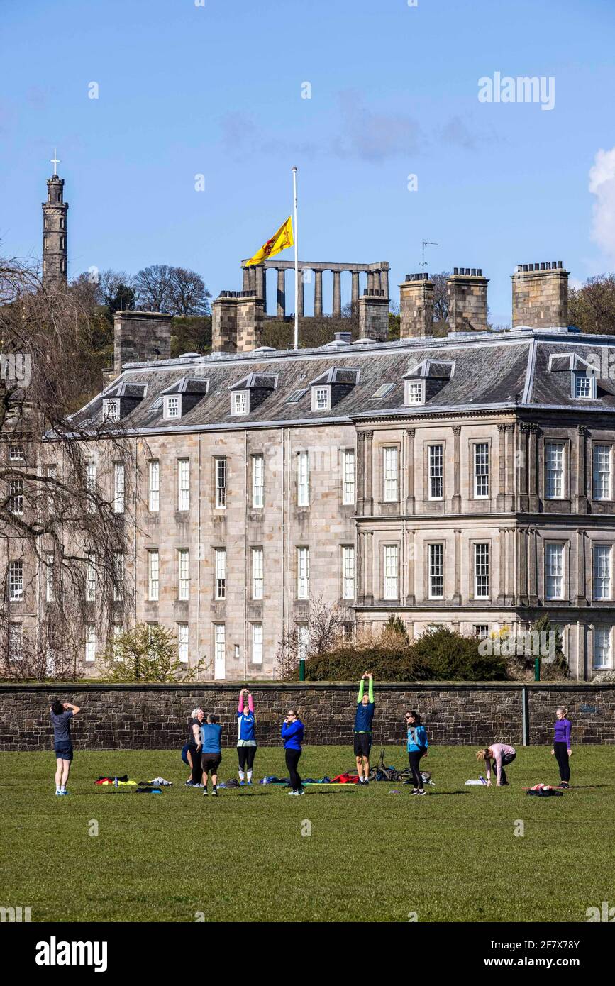 Edinburgh, Royaume-Uni. 10 avril 2021 photo : la vie se poursuit alors qu'un cours d'exercice se déroule dans le parc Holyrood, tandis que le drapeau de la Standard royale d'Écosse survole en Berne le palais de Holyroodhouse à Édimbourg pour marquer la mort du prince Philip, duc d'Édimbourg. Crédit : Rich Dyson/Alay Live News Banque D'Images