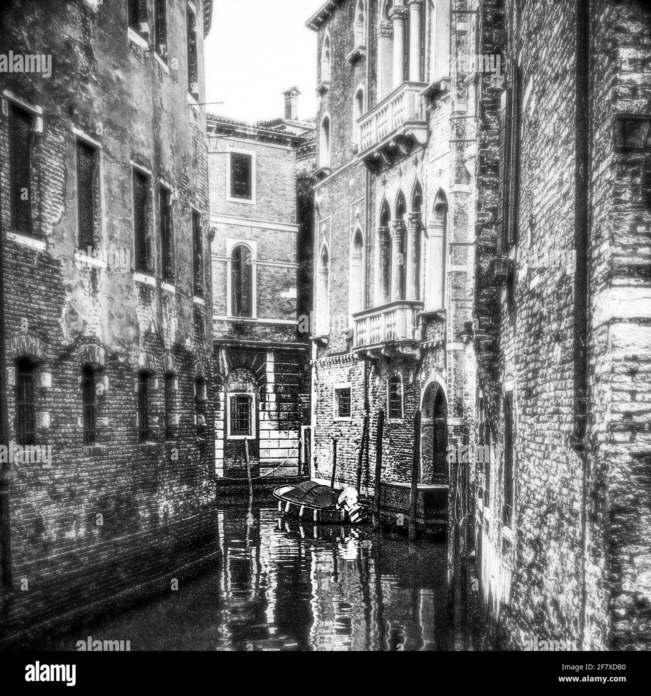 Vue en noir et blanc sur un petit canal de Venise un bateau est en train d'amarrer Banque D'Images