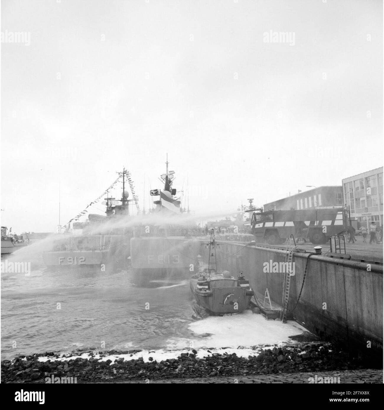 Un camion de pompiers de la marine sur une jetée en action pendant les 1989 jours de la flotte à Den Helder.Op le premier plan un extincteur naval (navire d'atterrissage, L 9522, 1963, embarcation auxiliaire (LCA) de type polyester MK i) Et sur les liens de fond la Frégate belge BNS Hiker (F 912, 1978, Cycling Class) et le néerlandais L-Frégate HR.Melle De blanc avec (F 813). Banque D'Images