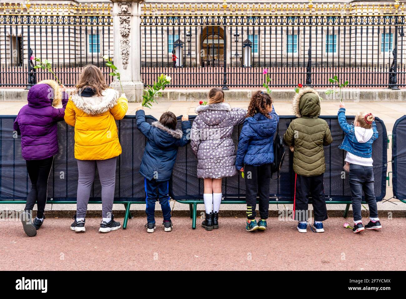 Buckingham Palace, Londres, Royaume-Uni. 10 avril 2021. Des enfants font la queue devant le palais de Buckingham pour déposer des fleurs aux portes à la mémoire du duc d'Édimbourg (prince Philip) décédé le 9 avril. Crédit : Grant Rooney/Alay Live News Banque D'Images