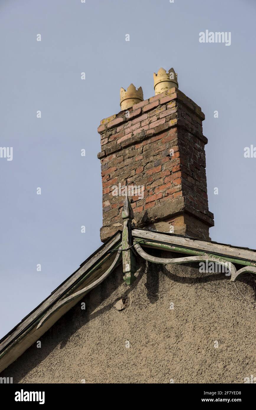 Vieille cheminée en brique rouge sur la maison en mauvais état nécessitant des réparations et des pointér, pays de Galles, Royaume-Uni Banque D'Images