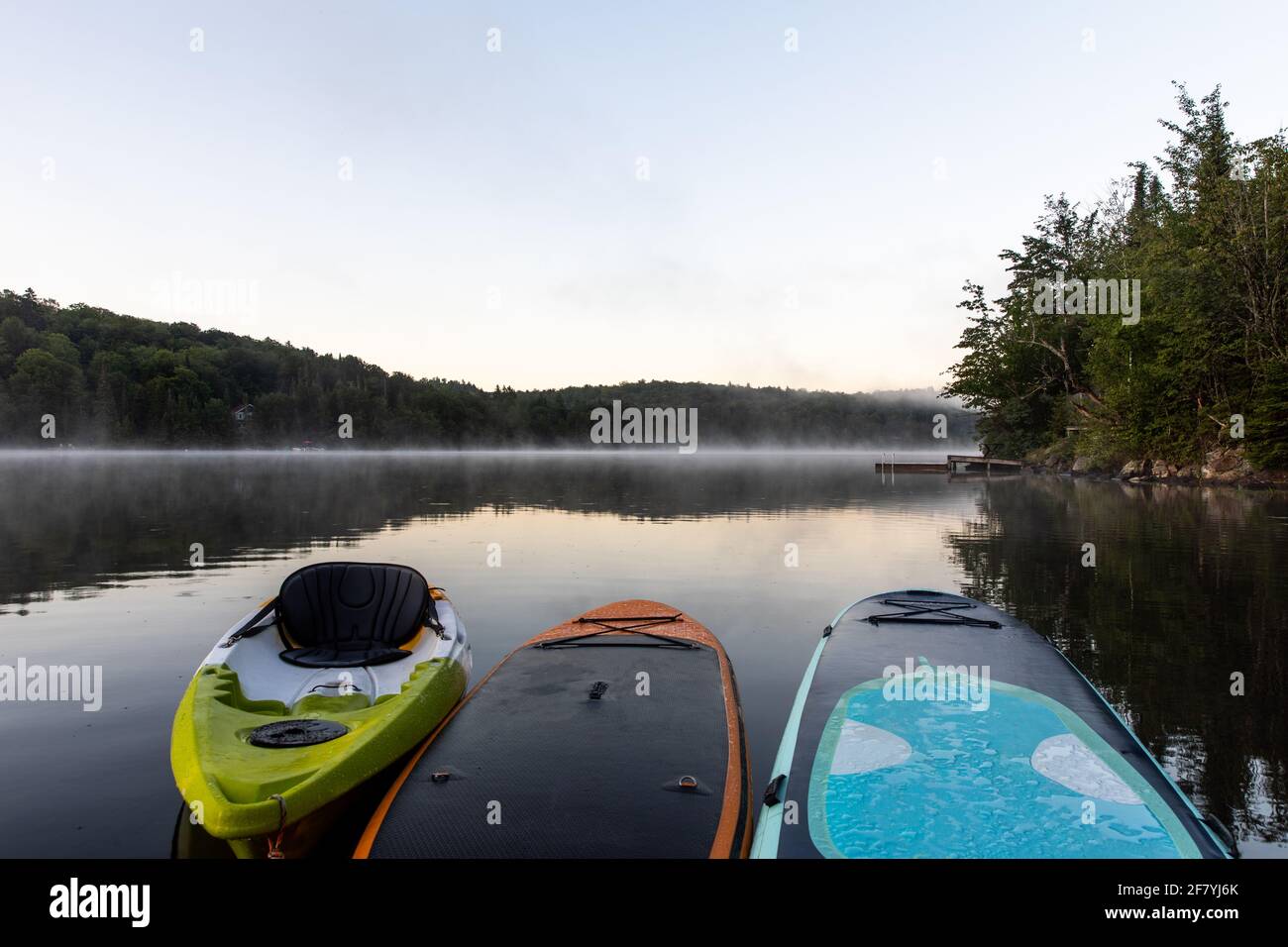 des planches et du kayak sur un lac tôt le matin avec le brouillard dans la distance Banque D'Images