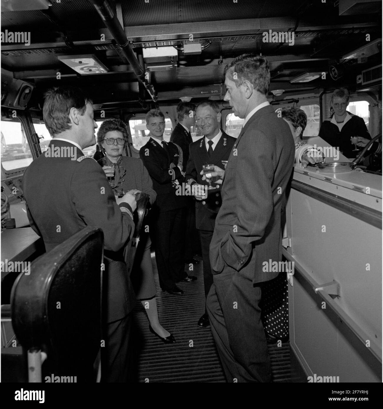 L'ambassadeur de Belgique (en façade centrale) visite la base navale Den Helder en mars 1990 et monte sur le pont à bord du L-Fregat HR.Melle White de with (1986-2005) offrait une boisson. Diagonalement laissé derrière l'ambassadeur le commandant de la force navale (CZM) est le vice-amiral J.D.W. Van Renesse (1934). Banque D'Images