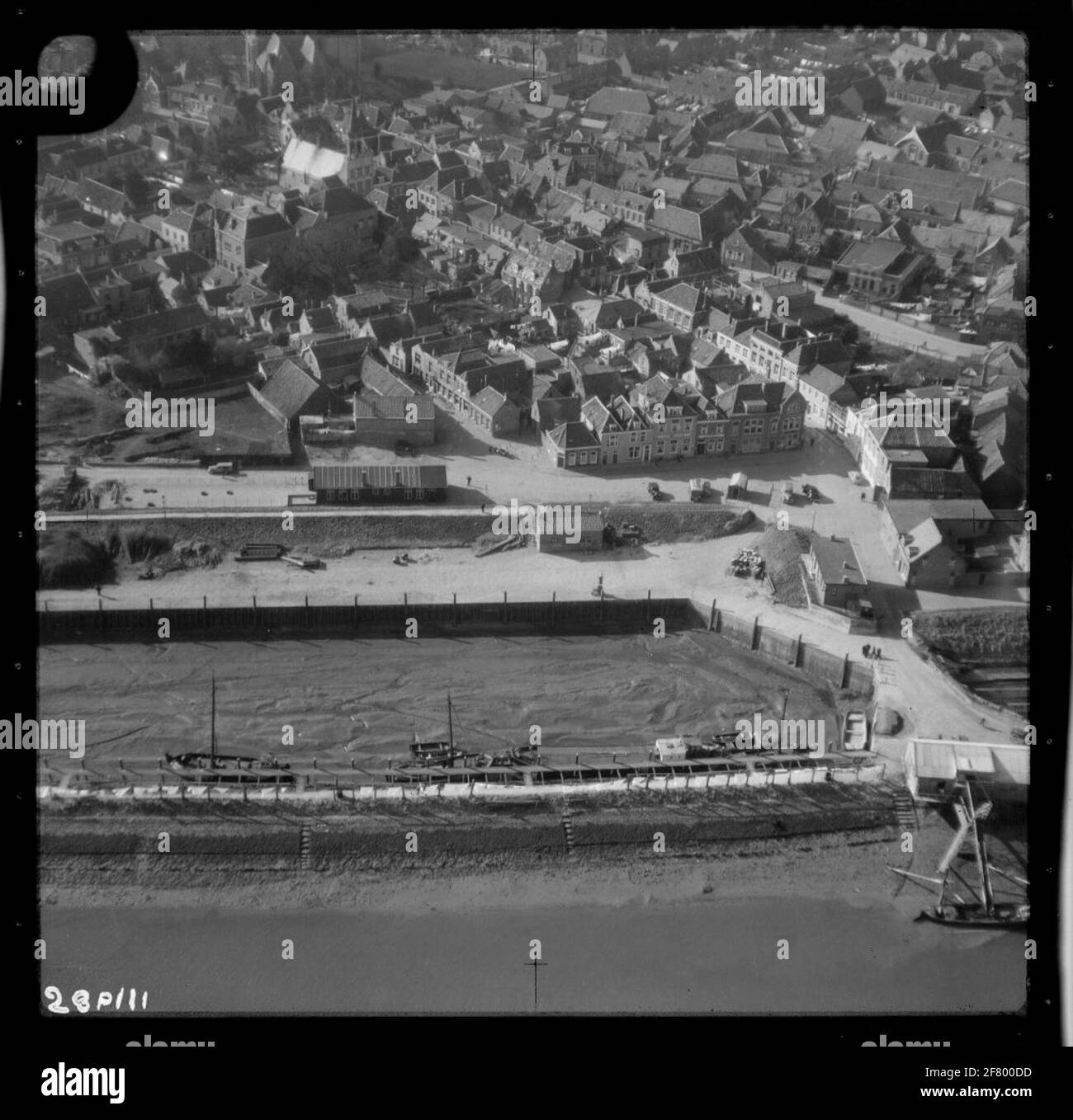 Catastrophe de la pénurie d'eau 1953. Photo aérienne de Tholen. Le port avec la place du port et le kaaij. Le bâtiment blanc avec tourelle, à l'étage supérieur, est l'hôtel de ville sur la Hoogstraat avec la grande ou chère église de la Dame au-dessus. Banque D'Images