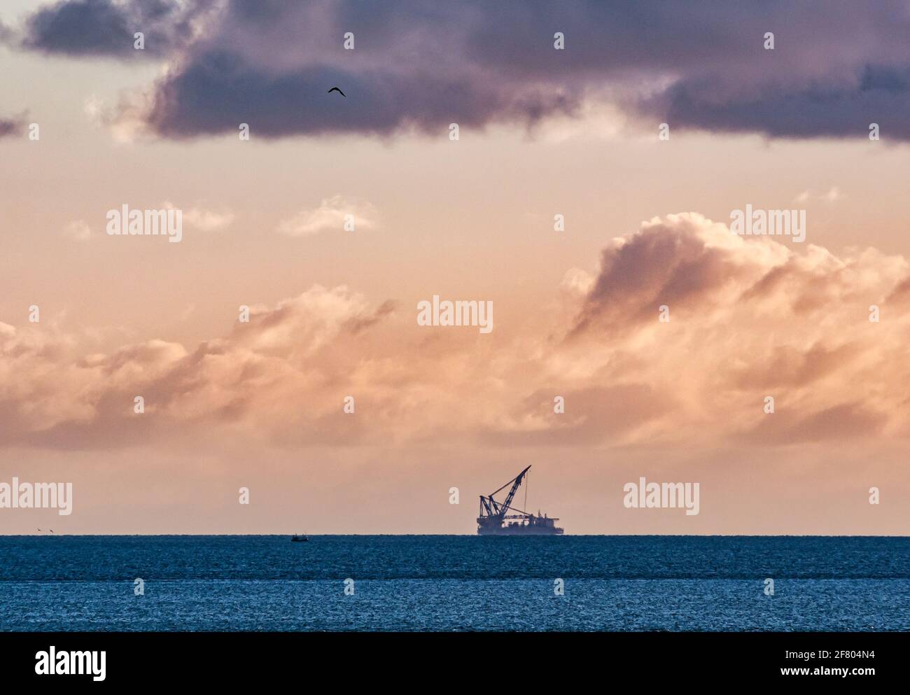 Vue lointaine au lever du soleil du navire-grue semi-submersible Saipem 7000 travaux en mer sur le projet de parc éolien Neart na Gaoithe (NNG), Mer du Nord, Écosse, Royaume-Uni Banque D'Images