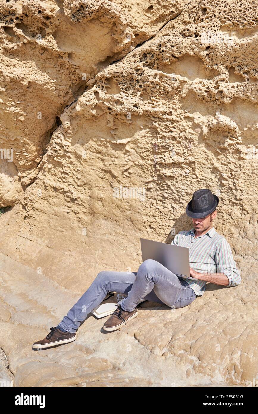 Un jeune auteur de voyage aime travailler sur son ordinateur portable de la plage Banque D'Images