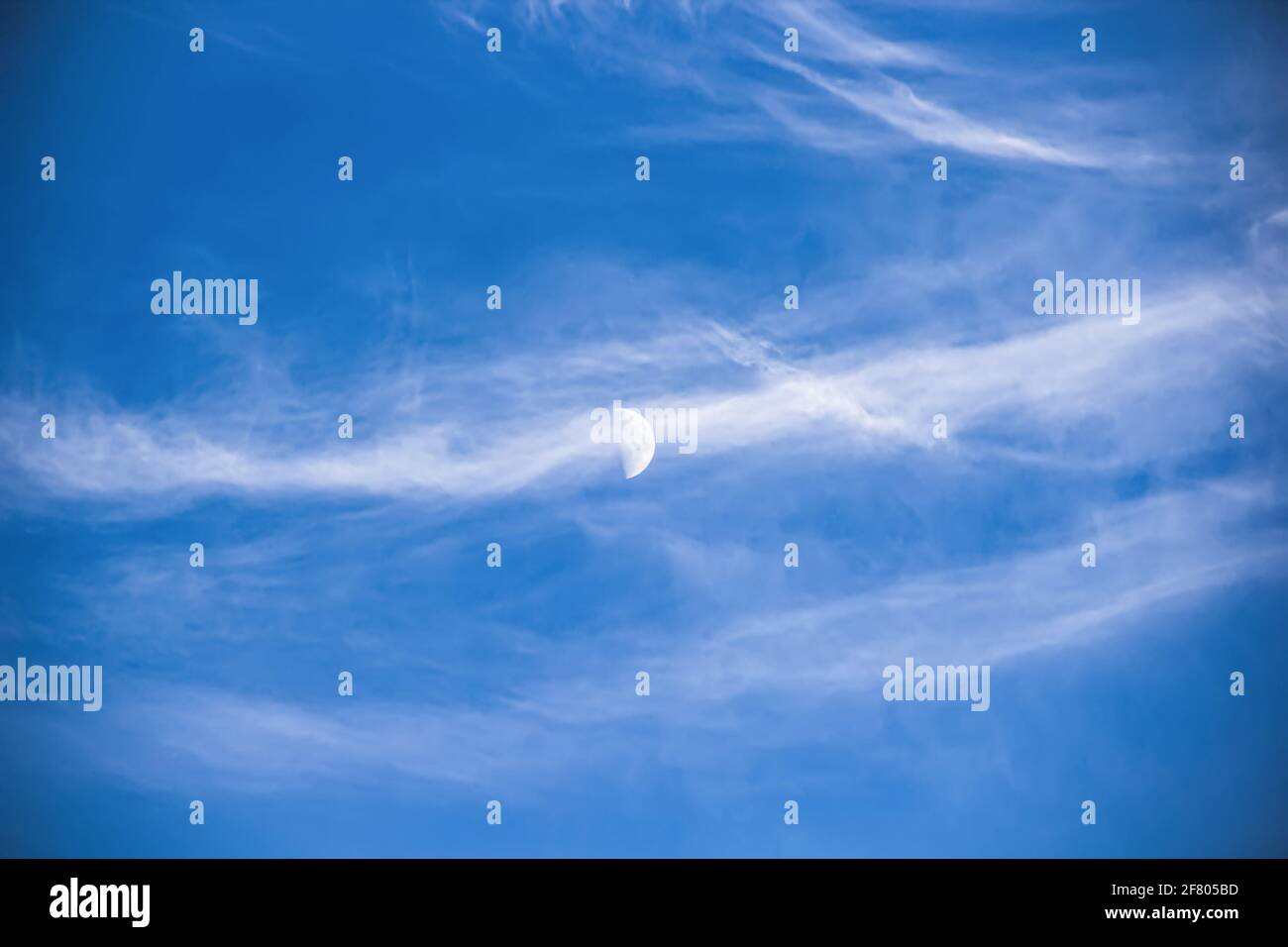 Gros plan sur le ciel de l'été. Beaucoup de nuages doux ont bloqué la lune, qui est faiblement visible dans le ciel bleu clair. Beauté naturelle Banque D'Images