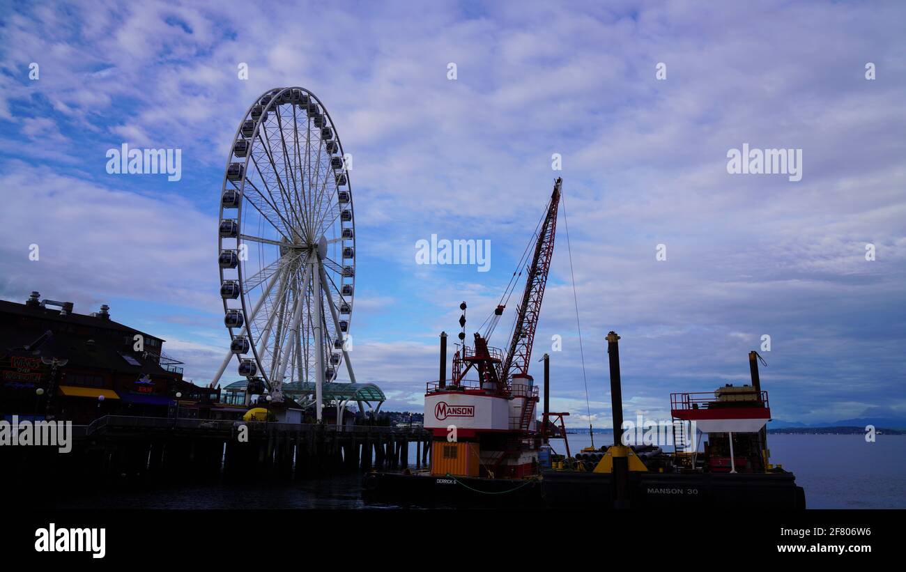 La Grande roue à l'embarcadère 57 de Seattle, Washington, États-Unis, sous ciel nuageux avec grue à proximité. Banque D'Images