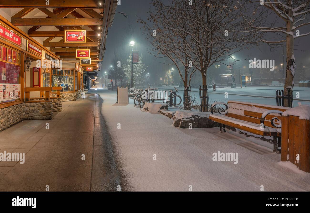Banff, Alberta, Canada – le 10 avril 2021 : vue extérieure des affaires de l'avenue Banff pendant une chute de neige en début de matinée Banque D'Images