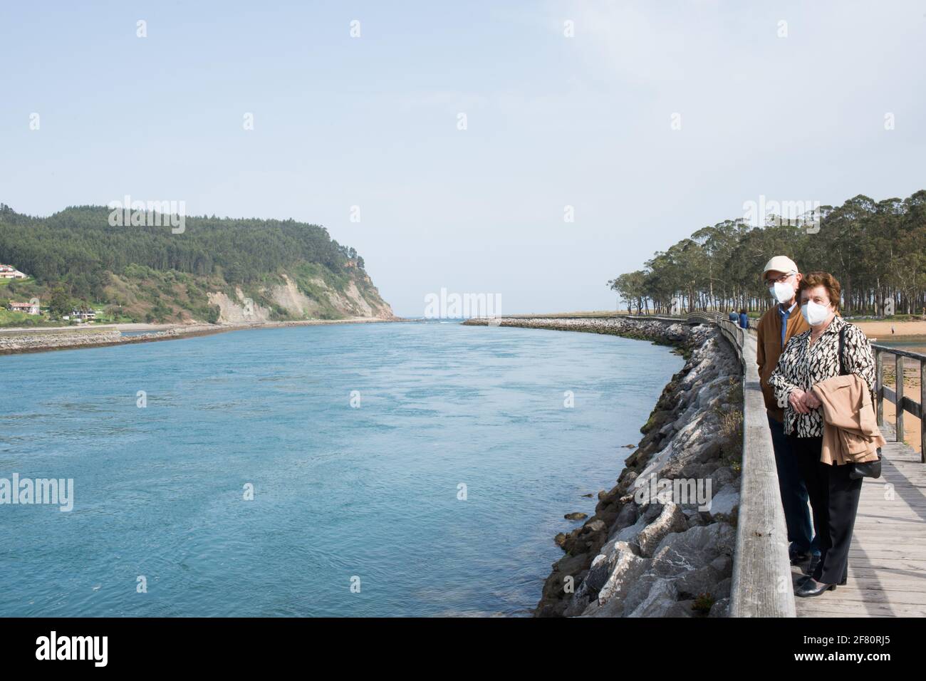 Couple âgé de 70-80 ans marchant à Rodiles, suivant un chemin en bois à côté de la rivière, Asturies Banque D'Images