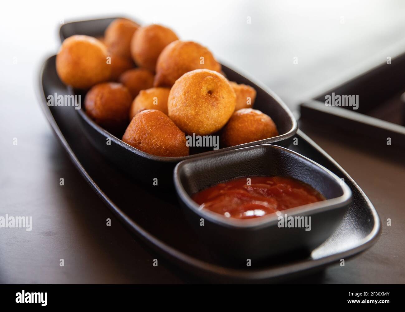 délicieux amuse-bouche avec sauce rouge dans une assiette noire Banque D'Images