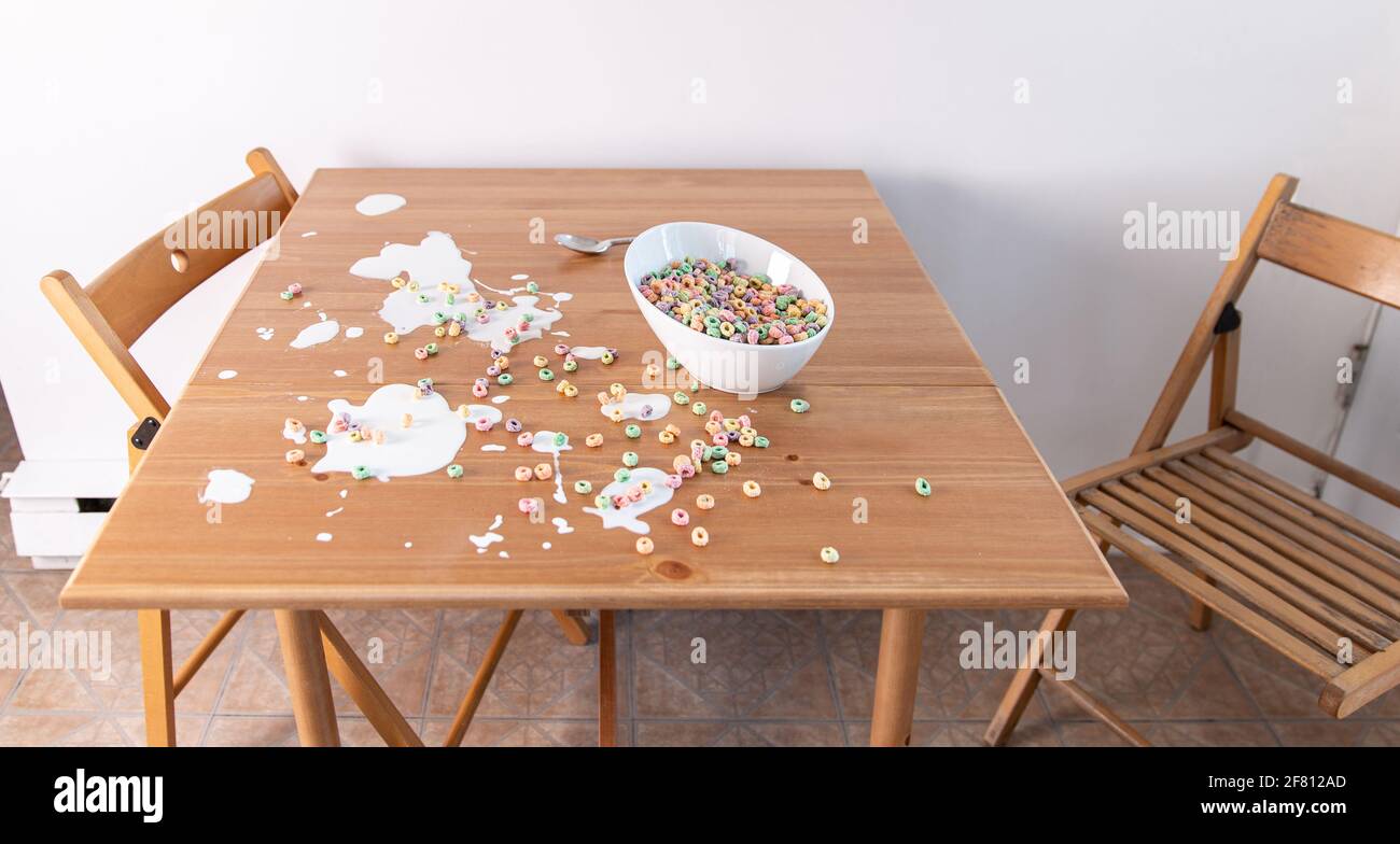 bol à céréales renversé sur une table en bois Banque D'Images bol à céréales renversé sur une table en bois Banque D'Images